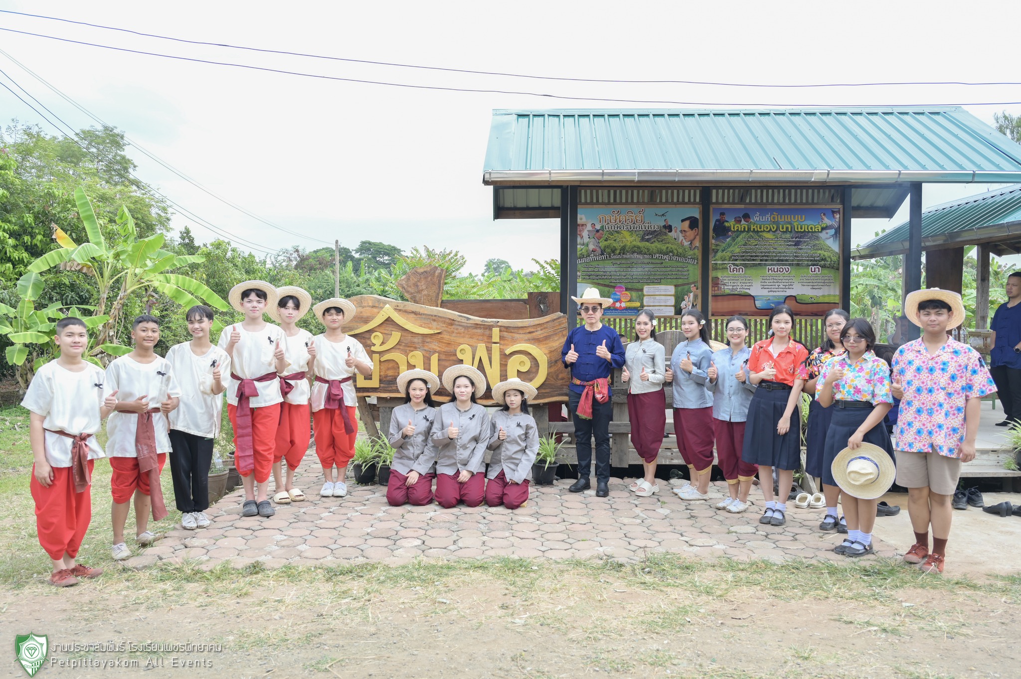 คณะครูและนักเรียนร่วมถ่ายภาพหน้าป้ายบ้านพ่อ